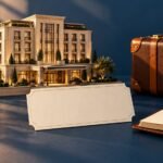 Miniature unbranded hotel beside a blank certificate, brown travel case and open ledger.